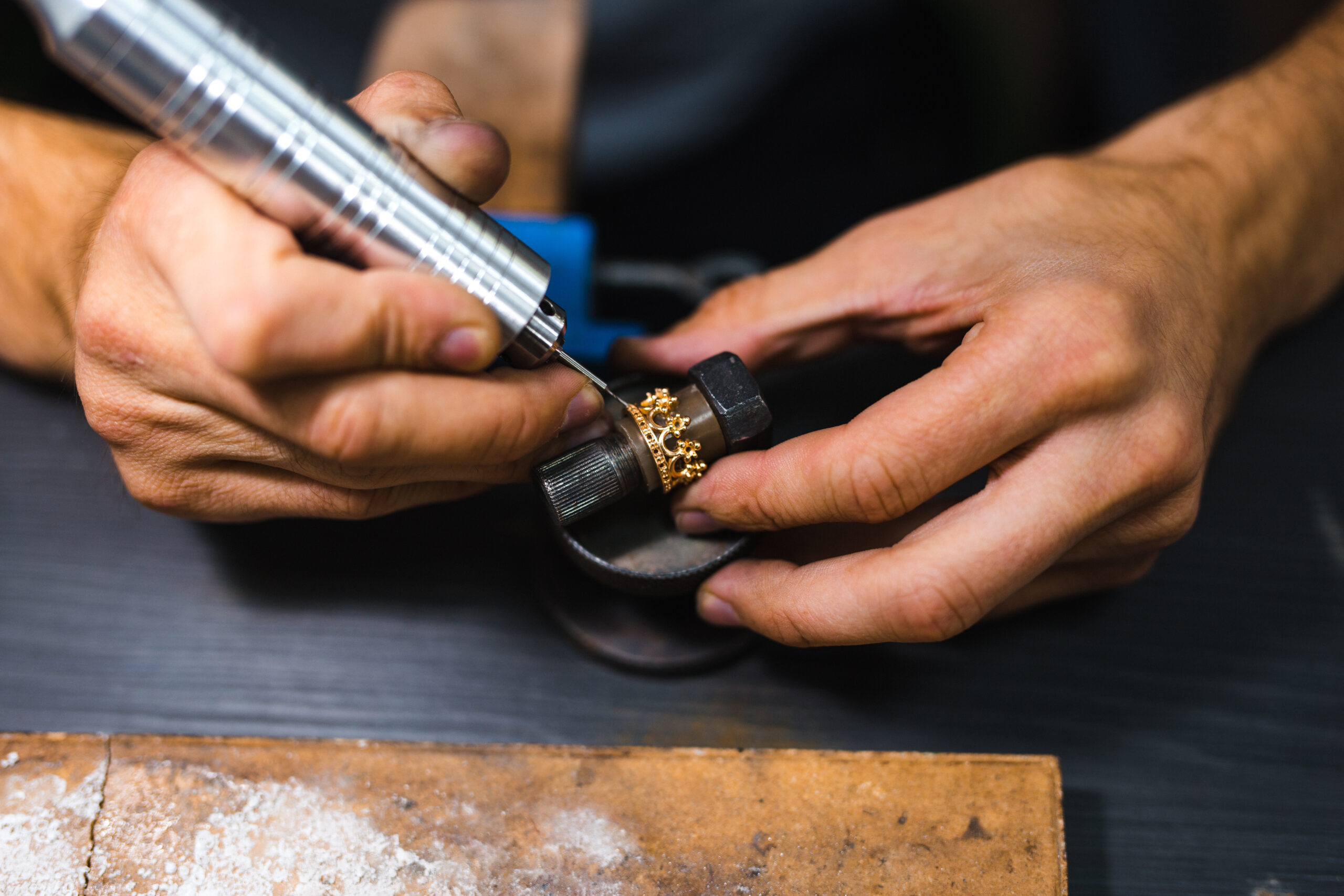Master of jewelry while working on making a gold ring. Top view.